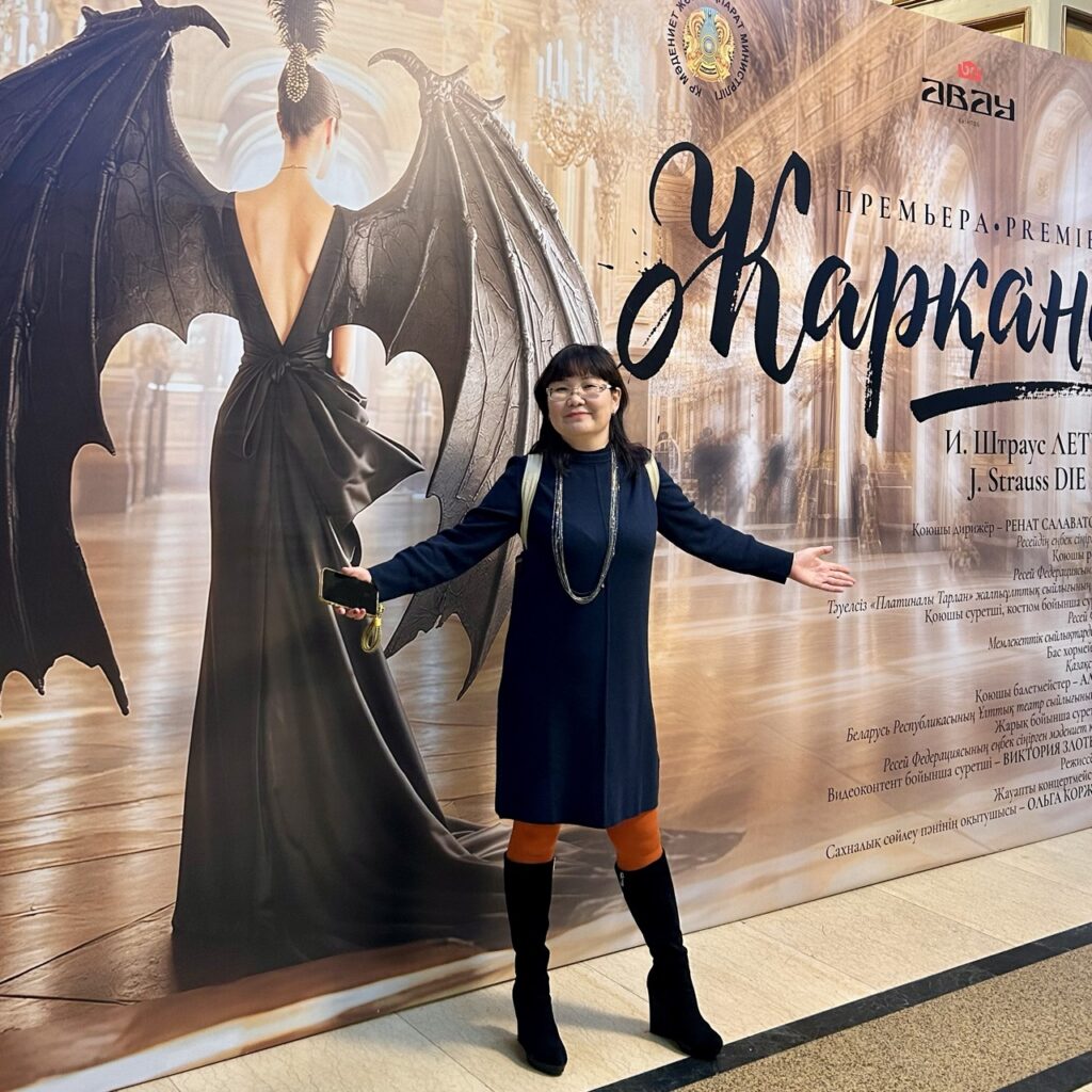 Пресс-стена "Жарқанат - Летучая мышь", Иоганна Штрауса. На фоне пресс-стены Анелия Мухамедкаримова.